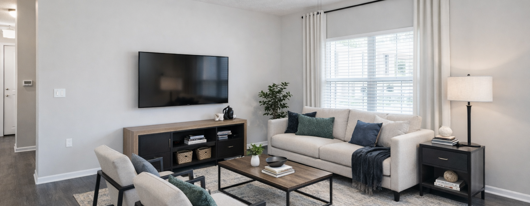 Staged apartment living room with green and blue accents