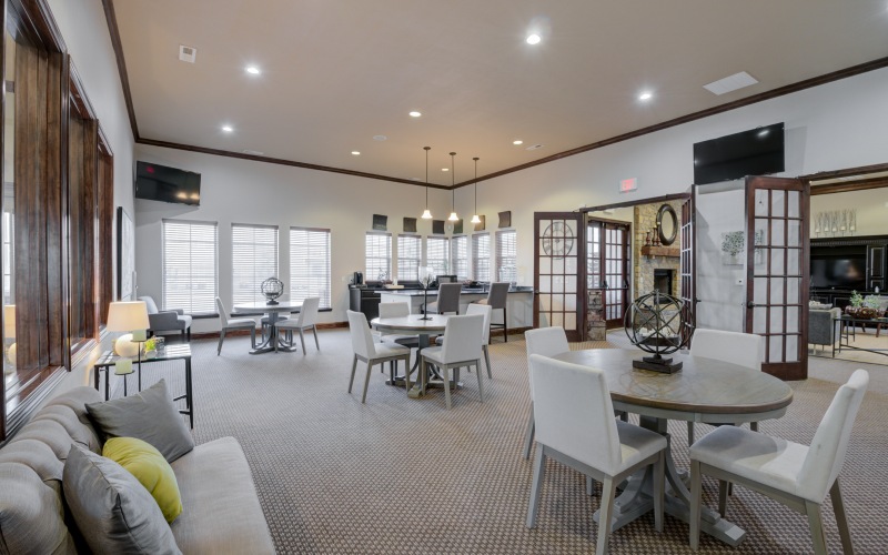 resident clubhouse with tables, chairs, and couch